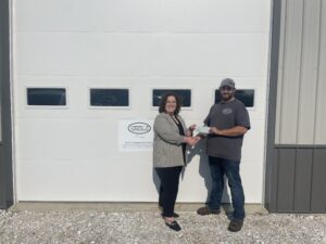 Maria Kuhns presents Leighton Jones with HIDC revolving loan fund check.